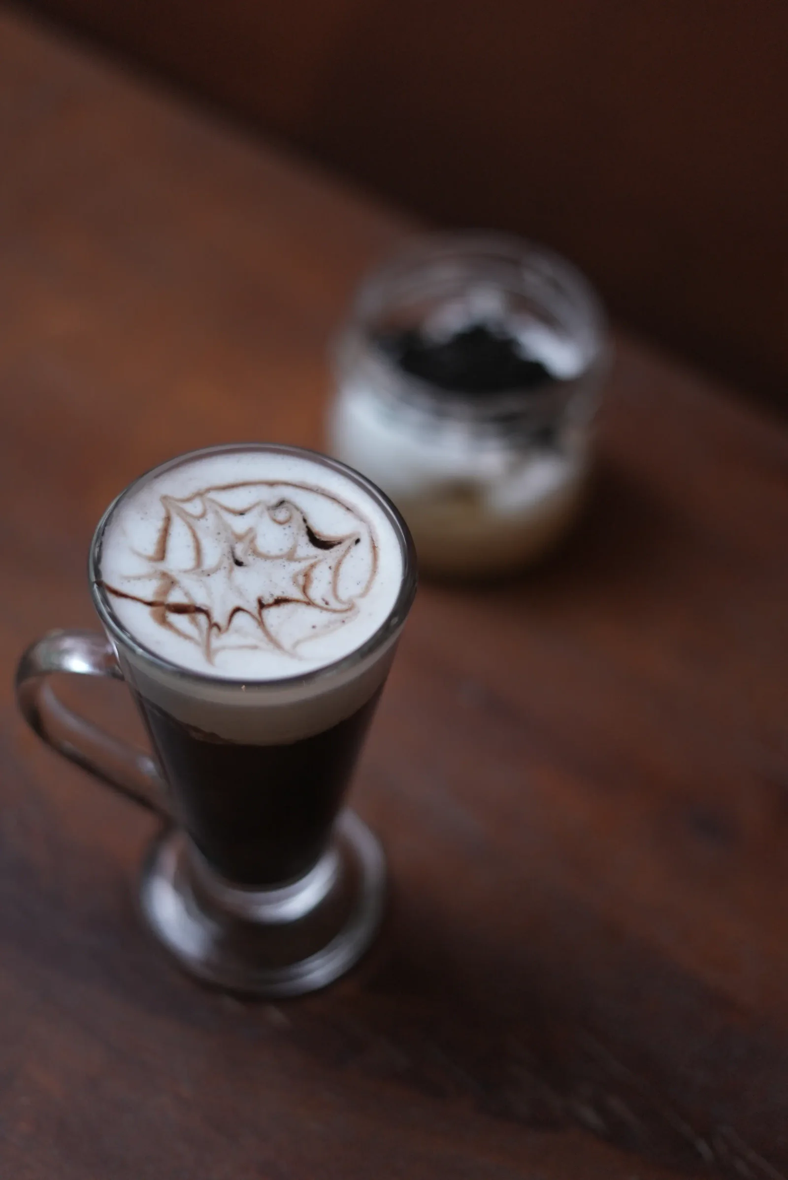 Hot chocolate served in a tall glass with cocoa latte art at Saanjh The Bistro, Jodhpur