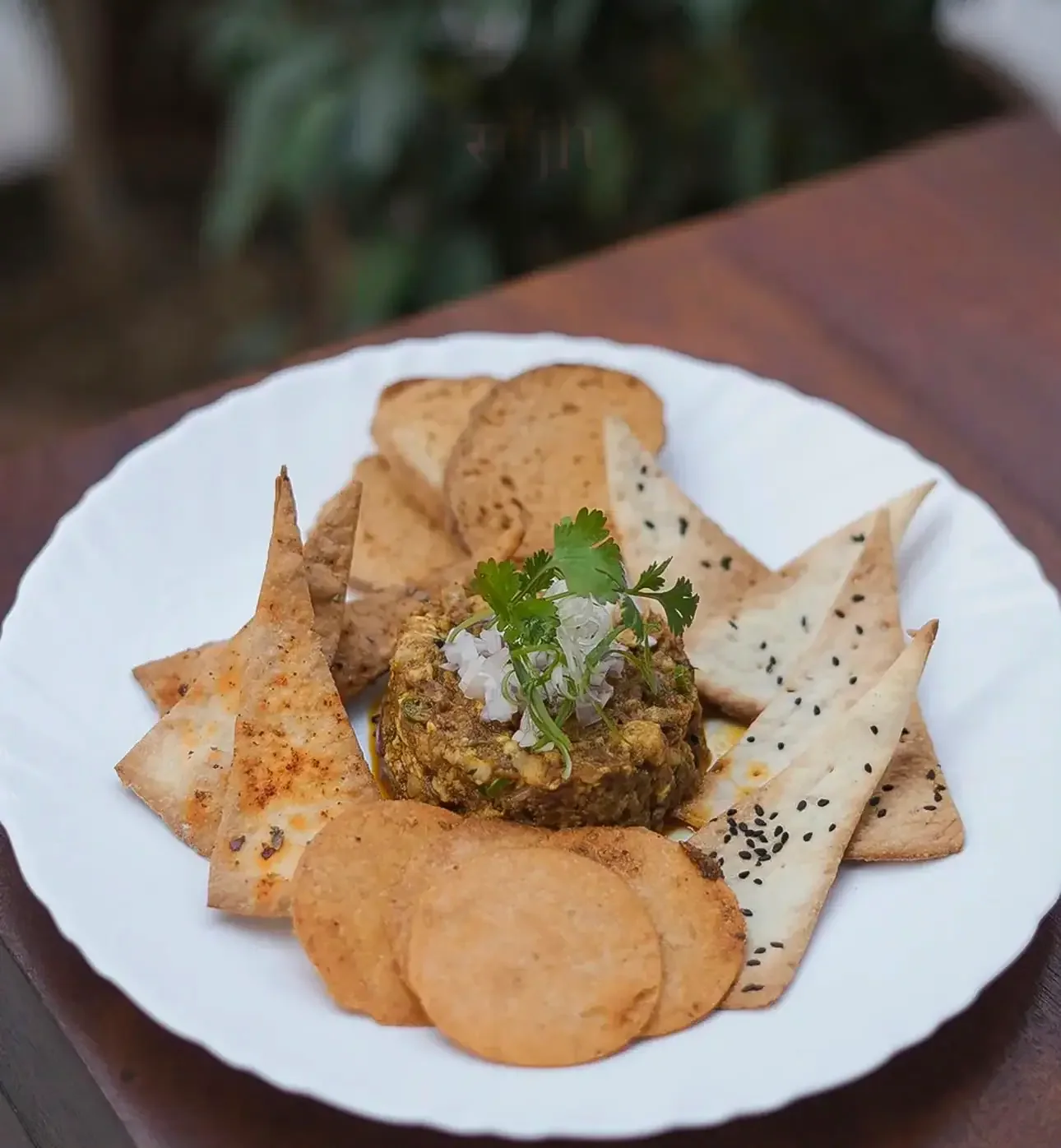 Hummus topped with herbs, surrounded by wedges of warm pita bread, at Saanjh The Bistro, Jodhpur