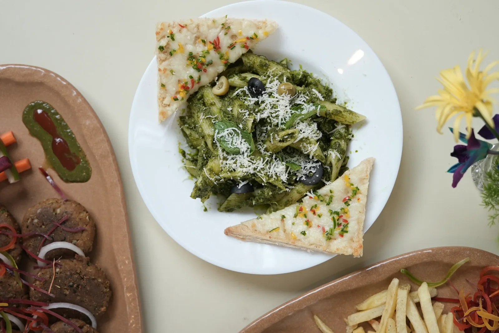 A plate of green pesto pasta served with wedges of flatbread at Saanjh The Bistro, Jodhpur